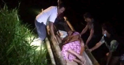 Seorang pasien di Kabupaten Pulau Morotai diseberangkan melalui sungai menggunakan rakit.