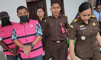 Tersangka ECDS dan MNN dengan tangan diborgol digiring menuju mobil tahanan Kejari Fakfak