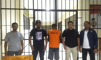 Polisi mengawal seorang tersangka perekrut serta pemasok PMI Ilegal di Mapolda NTT, Minggu (1/6)