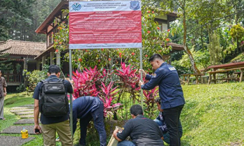 Tim Gakkum KLH memasang papan pengawasan ketika menyegel empat hotel karena pencemaran lingkungan di Puncak, Kabupaten Bogor, Jawa Barat